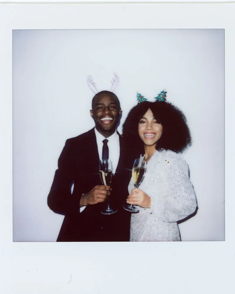 Tirage instantané d’un couple en tenue de fête, coupes de champagne à la main