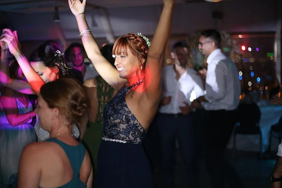 Invitée qui danse bras levés sous les lumières colorées d’une soirée de mariage à Marseille