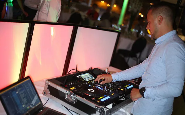 Mains d’un DJ sur ses platines pendant une soirée de mariage à Marseille