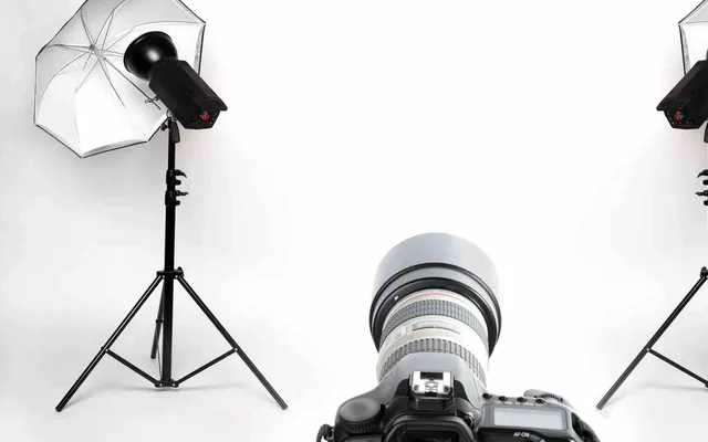 Appareil photo reflex et objectif vus en contre-plongée entre les flashs du studio AlloPhotoMarseille
