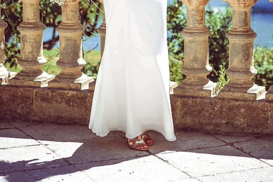 Mariée en pied devant une balustrade de pierre des jardins du Pharo, le Vieux-Port de Marseille en arrière-plan