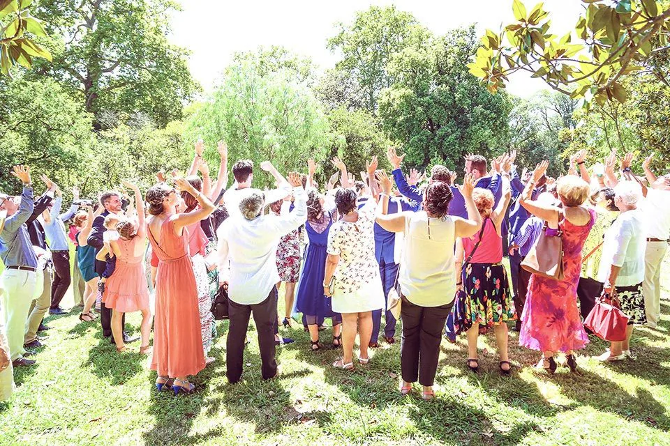 Invités bras levés dans un parc pendant un vin d’honneur de mariage à Marseille