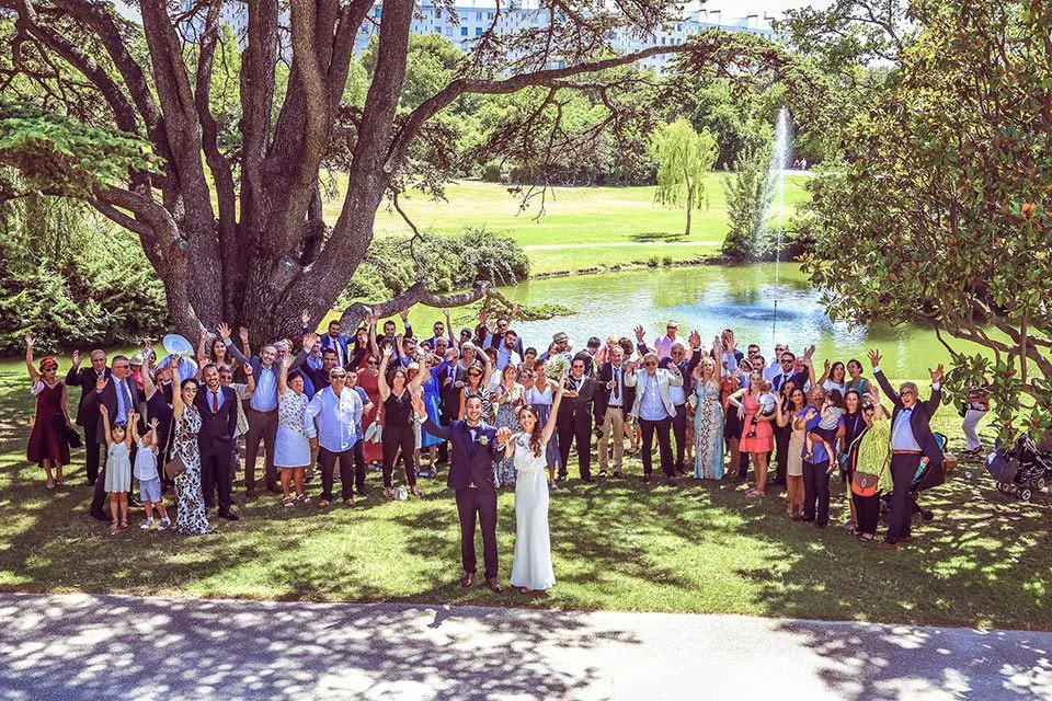 Photo de groupe de tous les invités d’un mariage dans un parc de Marseille, autour des mariés