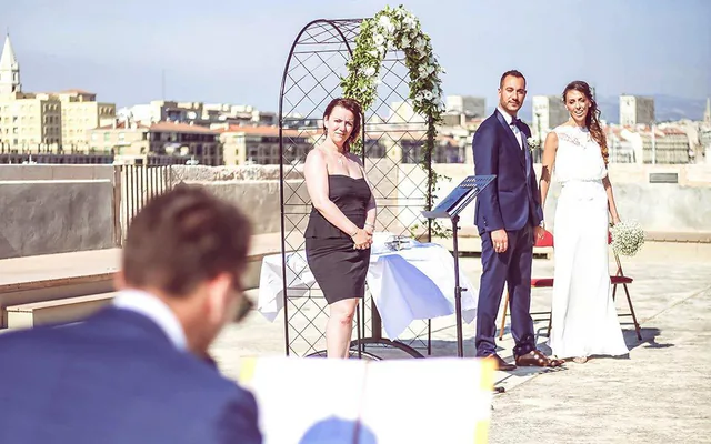 Pianiste devant une assemblée lors d’une cérémonie en plein air, avec Marseille en arrière-plan