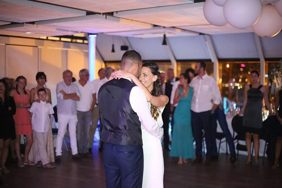 Ouverture du bal des mariés entourés de leurs invités dans une salle de réception