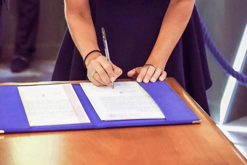 Témoin en robe bleue qui signe le registre lors d’un mariage civil à Marseille