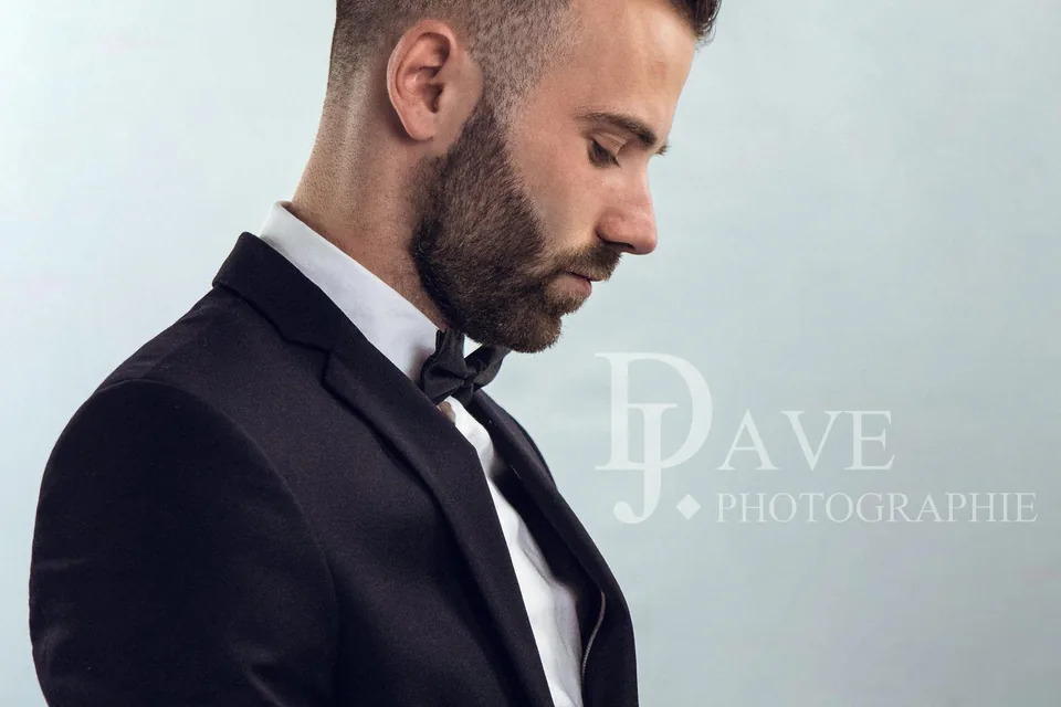 Homme en smoking et nœud papillon photographié sur fond blanc au studio à Marseille