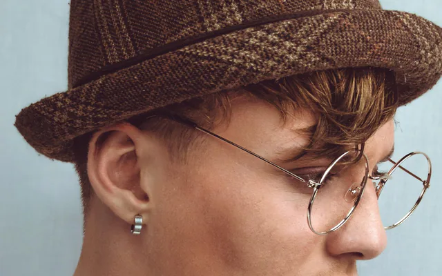 Portrait en studio d’une jeune personne aux lunettes rondes, fond blanc
