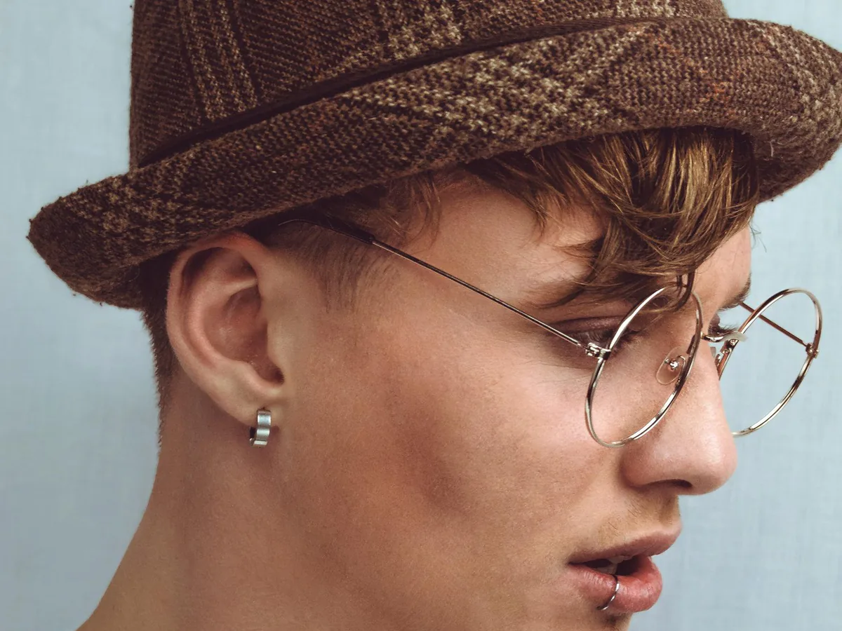 Portrait en studio d’une jeune personne aux lunettes rondes, fond blanc