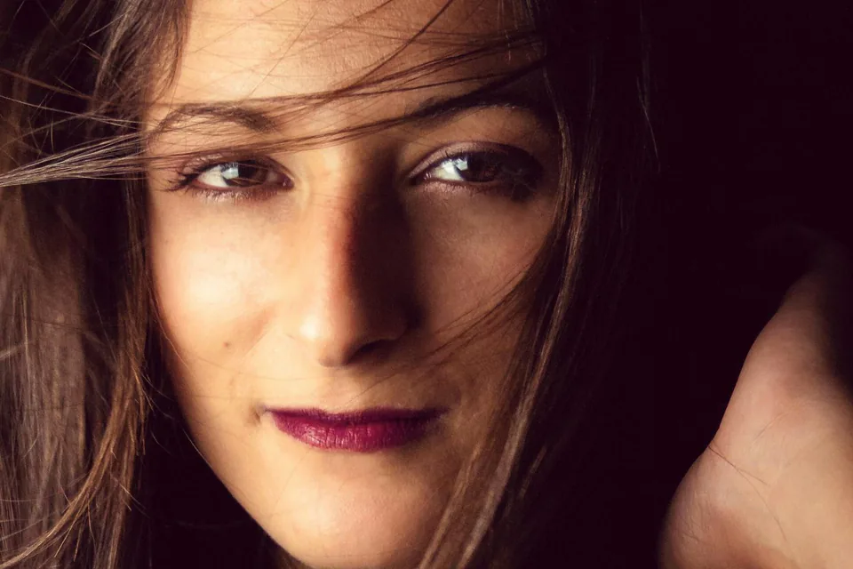 Portrait en lumière douce au studio de Marseille, fond sombre et cheveux au vent