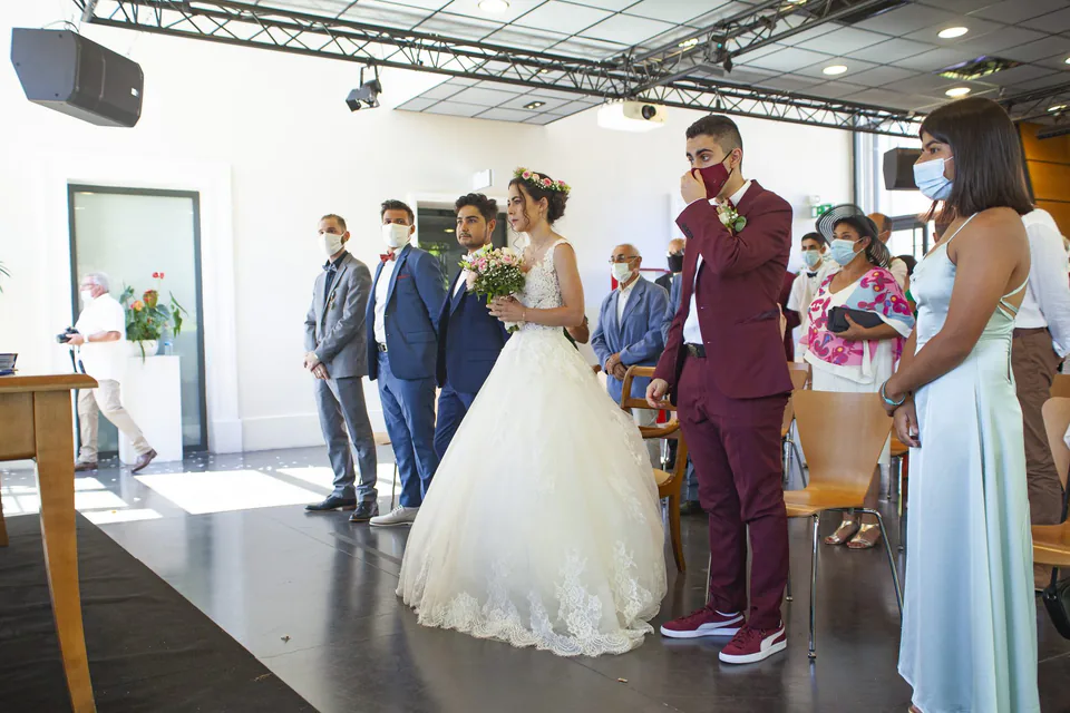 Mariés debout à la mairie, marié en costume bordeaux, lors d’un mariage civil à Marseille