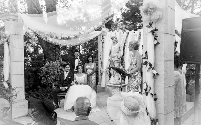 Cérémonie laïque de mariage en noir et blanc, l’assistance sous une arche de voilages, en Provence
