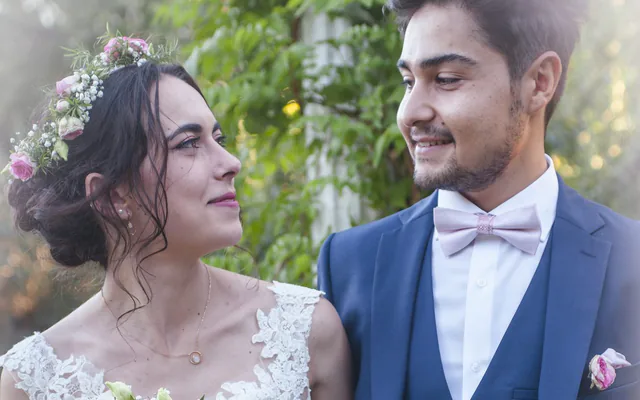 La mariée regarde son mari en souriant, bouquet de roses à la main, lors d’un mariage à Marseille
