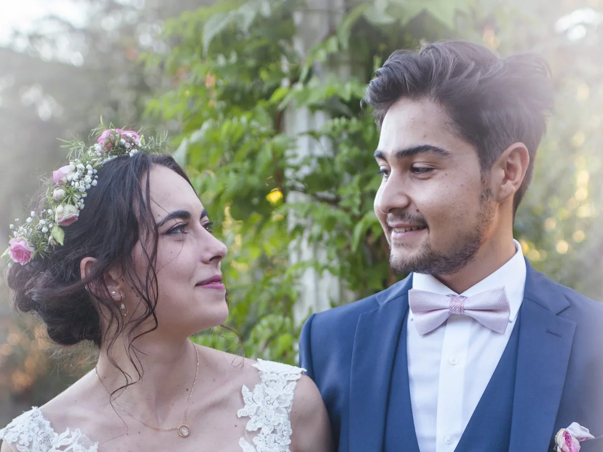 La mariée regarde son mari en souriant, bouquet de roses à la main, lors d’un mariage à Marseille